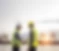 日の暮れるポートターミナルを背景に、二人の従業員が１枚のドキュメントを手に取って確認している様子の写真
